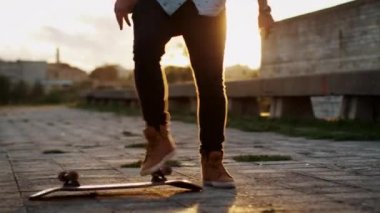 Kickflip açık havada günbatımı ışıkta gerçekleştirme kaykaycı.