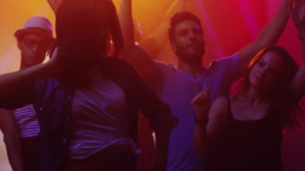 Mensen dansen, plezier en verhogen handen in nachtclub. — Stockvideo