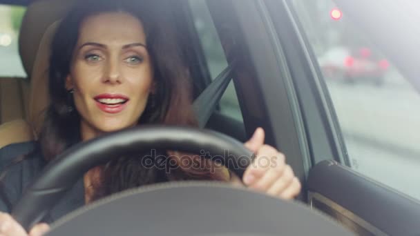 Ενθουσιασμένος ελκυστική γυναίκα που ακούτε μουσική κατά την οδήγηση ενός αυτοκινήτου. — Αρχείο Βίντεο