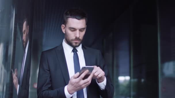 Zakenman die gebruik maakt van mobiele telefoon buiten — Stockvideo