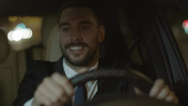 Щасливий усміхнений бізнесмен водіння автомобіля ввечері — стокове відео