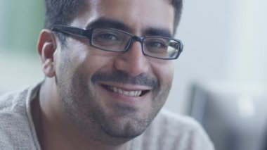 Gözlüklü genç gülümseyen adam portresi