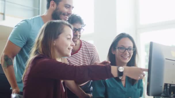 Groupe d'étudiants souriants et riants de race mixte travaillant en équipe, pointant vers l'écran d'ordinateur . — Video