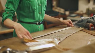 Genç kadın moda tasarımcısı Studio içinde çalışır. Teyp ölçüm kullanarak.