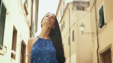 Avrupa şehir sokaklarında yürüyüş hafif yaz elbiseli çekici genç esmer kadın.