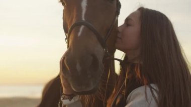 Genç kız okşayarak ve bir at sarılma