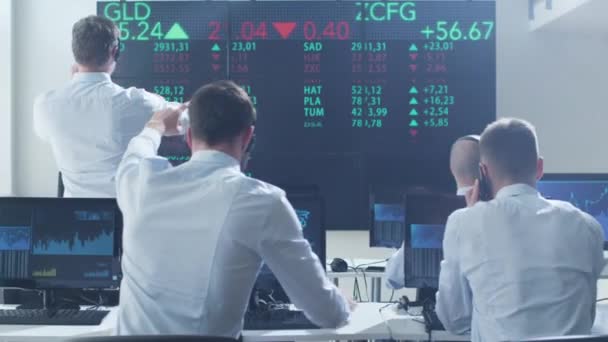 Grupo de corretores de ações que trabalham ativamente na Bolsa de Valores — Vídeo de Stock