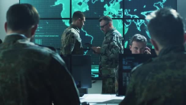 Grupo de Profissionais Militares de TI em Briefing na Sala de Monitoramento Preenchida com Displays na Base Militar — Vídeo de Stock