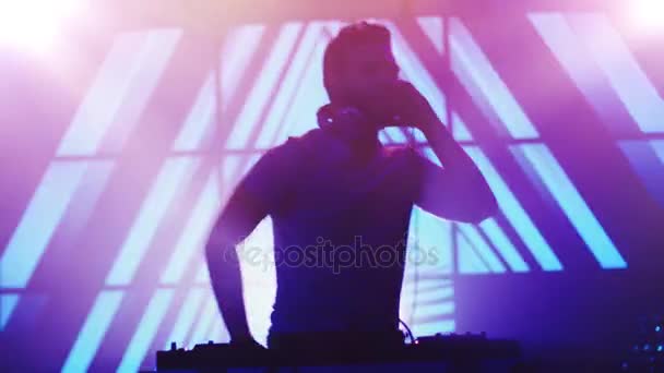 Backlit Dj spelen muziek in de discotheek. Silhouet van een Dj. Bright animatie op achtergrond. — Stockvideo