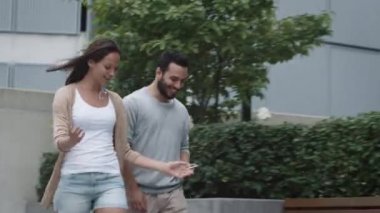 Genç gülümseyen kadın ve adam mısın Walking and Talking kentsel ortamda.