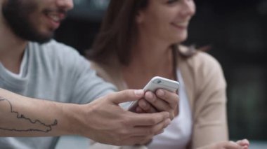 Genç gülümseyen kadın ve adam vardır kullanarak cep telefonu açık havada.