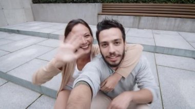 Gülüyor ve genç çift kameraya konuşurken gülümseyen.