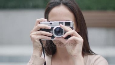 Klasik Rangefinder Film kamera ile fotoğraf çekmek genç çekici kadın kameraya bakarak ve gülümseyen.