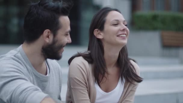 Un jeune homme et une jeune femme souriants et heureux communiquent à l'extérieur. Prise de vue au ralenti . — Video