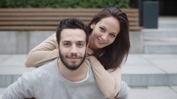 Retrato de casal sorridente feliz ao ar livre. Jovem mulher abraçando o homem — Vídeo de Stock