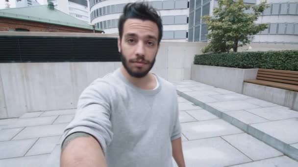 Ung Man Vlogger promenader utomhus och prata med kameran. — Stockvideo