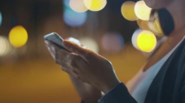 Yakın çekim çekim sırasında cep telefonu yürüyerek gece şehir sokakları kullanarak çekici kadın