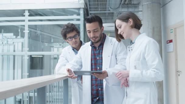 Groep studenten of Medical School hebben bijeenkomst in de hal van het College. Als we kijken naar Tablet PC. Gesprek voeren. — Stockvideo