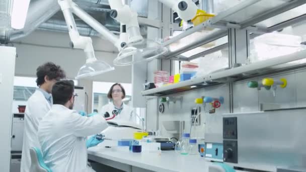 Équipe d'étudiants multiethniques en manteaux travaillant dans la salle de classe du Laboratoire de chimie . — Video