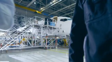 Uçak bakım işçi ve mühendis konuşmayı. Tablet holding.