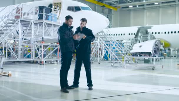 Équipe de mécaniciens d'entretien d'aéronefs regardant l'avion — Video