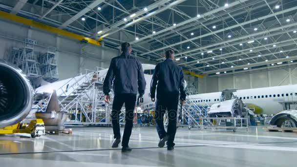 Team von Flugzeugwartungsmechanikern bewegt sich in Richtung Flugzeug — Stockvideo