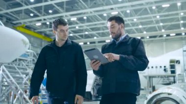 Takım uçak bakım mekaniğinin Hangar hareket. Tablet bilgisayar holding