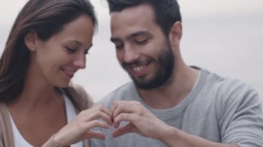 Mutlu gülümseyerek çekici çift şekillendirme Hearth işareti kendi elleriyle.