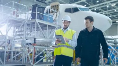 Takım uçak bakım mekaniğinin Hangar hareket. Tablet bilgisayar holding