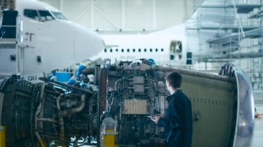 Uçak bakım makinist Inspecting ve hangarda Tablet uçak Jet motorunu kullanarak