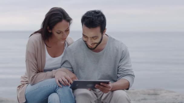 Sonriendo y riendo pareja atractiva usando Tablet Computer al aire libre . — Vídeo de stock