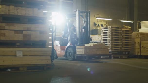 Forklift operator is driving in lumber factory warehouse. — Stock Video