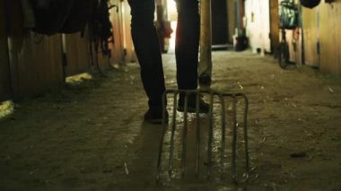 Bir adam bir dirgen yere sürükleyerek yakın çekim görüntüleri.