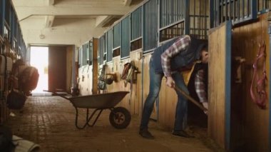 Adamın bir dirgen ile saman istikrarlıdan temizlemek.