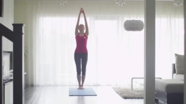 Genç kadının evde oturma odası yogada yapması