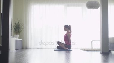 Genç kadının evde oturma odası yogada yapması