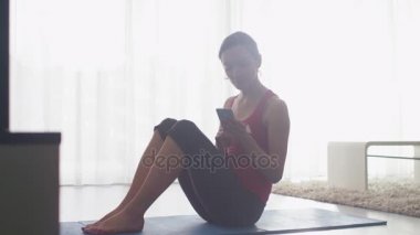 Genç kadının germe yapması ve Fitness evde oturma odasında.