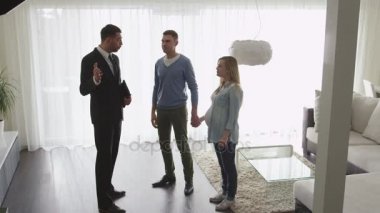 Emlakçı yeni daire çift için gösterir. Ajan ve insan arasında karşılıklı.