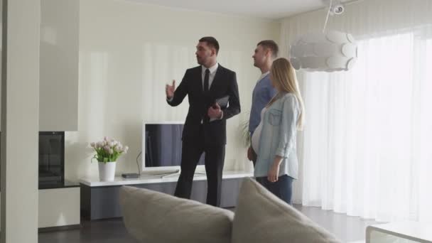 El agente inmobiliario muestra nuevos apartamentos a la pareja. apretón de manos entre agente y hombre . — Vídeo de stock