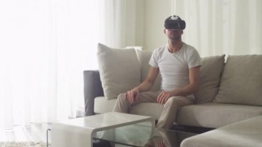 Oturma odası VR kulaklık giyen adam.