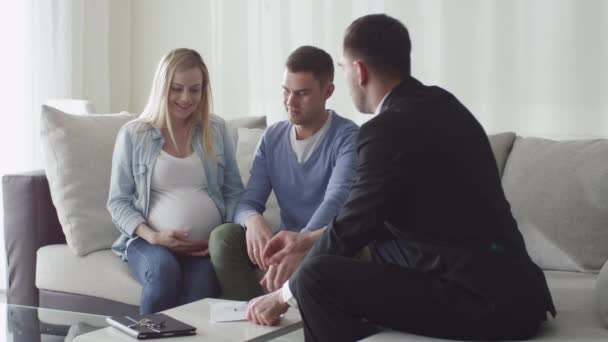 Šťastná rodina podepsání smlouvy s realitní kanceláří. Žena je těhotná.