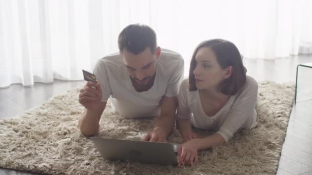 Ζευγάρι χρησιμοποιώντας το φορητό υπολογιστή για Online αγορές. Κρατώντας πιστωτική κάρτα. — Αρχείο Βίντεο