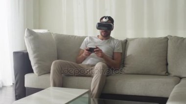 Vr kulaklık giyen ve oyun denetleyicisi ile oturma odası dostum.