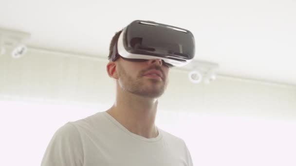 リビング ルームで Vr のヘッドセットを着ている男。手でジェスチャーを使用してください。. — ストック動画