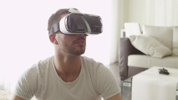 Homem vestindo fone de ouvido VR na sala de estar. Usando gestos com as mãos . — Vídeo de Stock