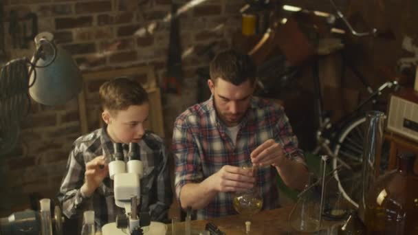 Father and son are making chemistry experiments in a garage at home. — Stock Video