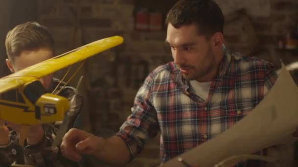 Pai e filho estão modelando um avião de brinquedo em uma garagem em casa . — Vídeo de Stock