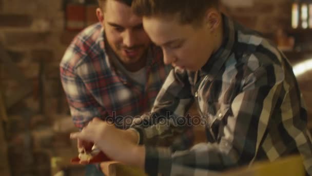 Father and son are woodworking in a garage at home. — Stock Video