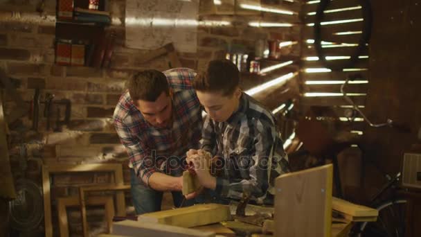 Отец и сын занимаются деревообработкой в гараже дома . — стоковое видео