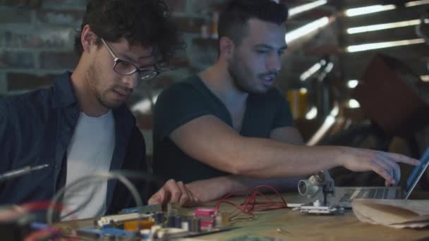 Dos estudiantes están estudiando electrónica y soldadura en un garaje . — Vídeos de Stock